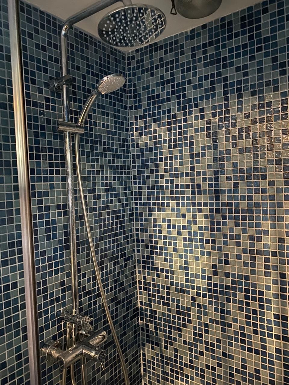 Deep-blue mosaic-tiled walk-in shower with rainfall head