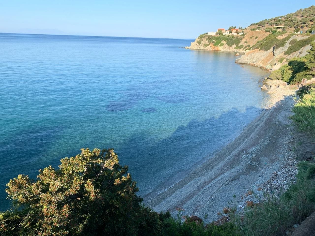 The pebble cove and clear water below the house