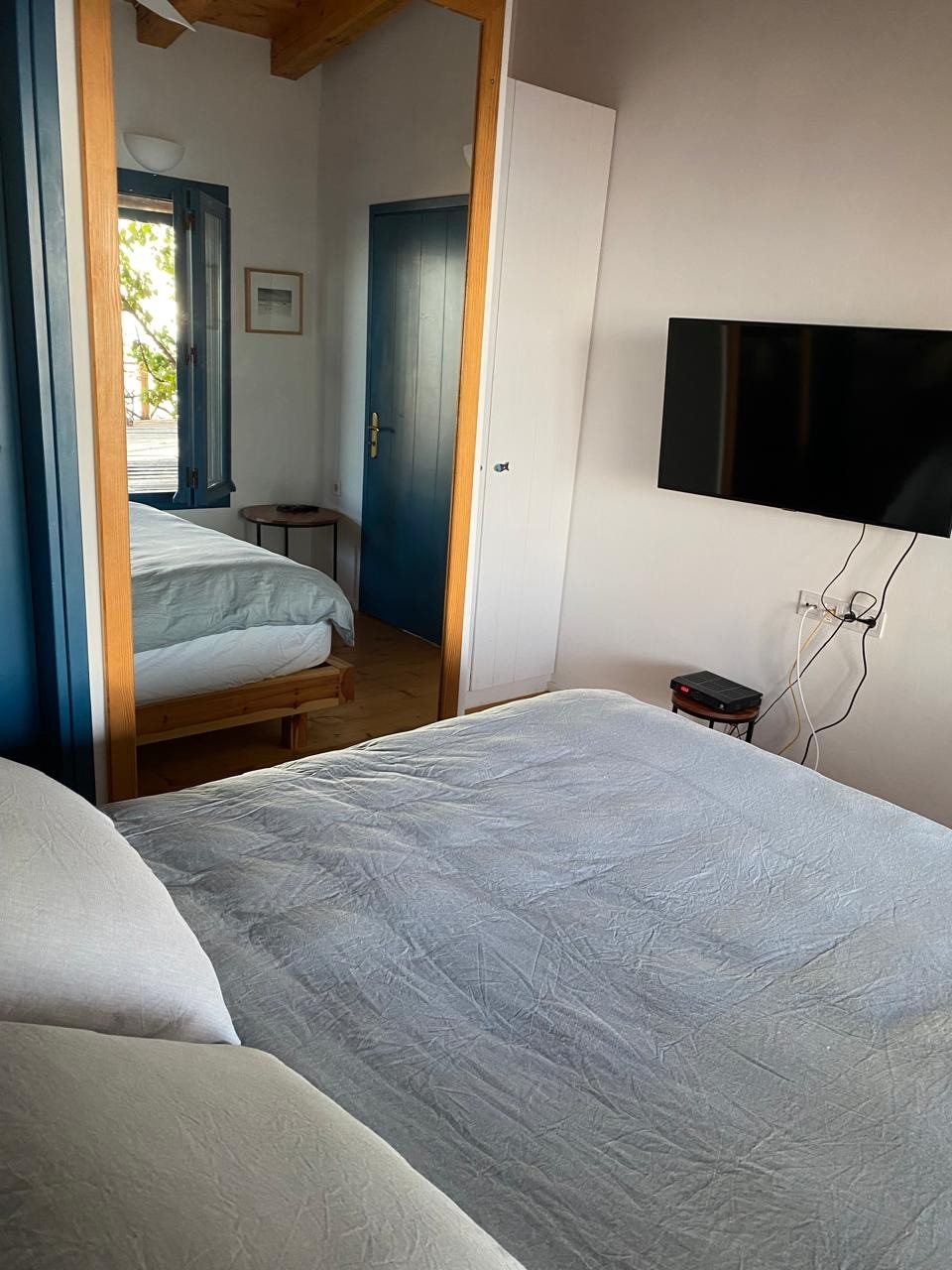 Bedroom with a wall-mounted TV and a double bed
