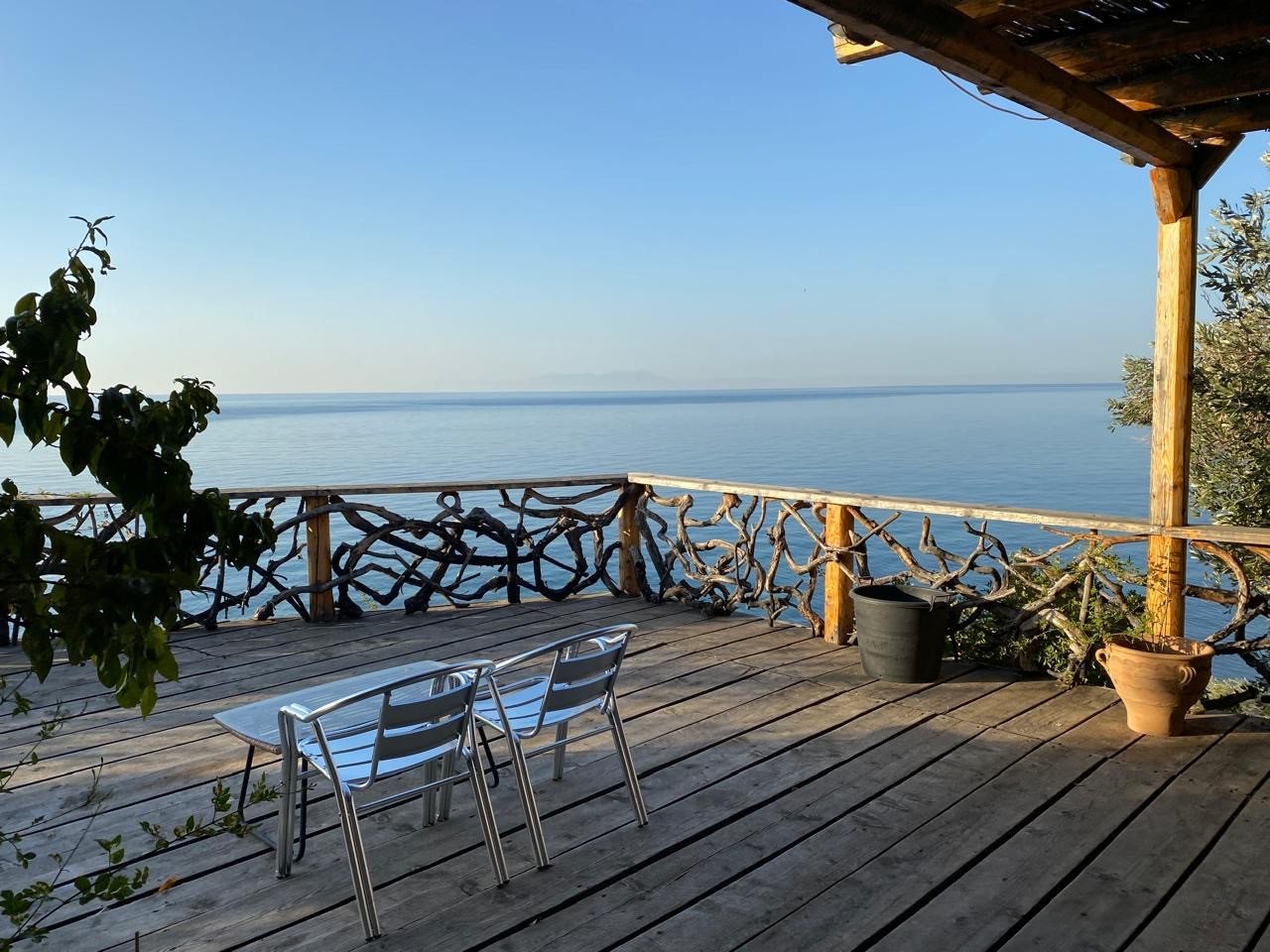 Deck table and chairs at the railing above the sea