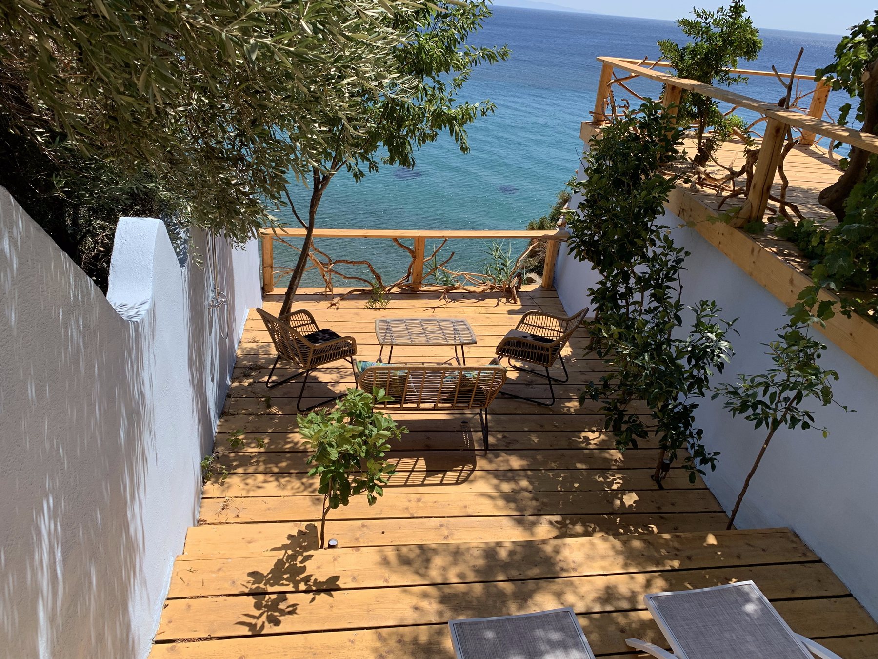 Sun loungers on the deck against whitewashed walls and the sea