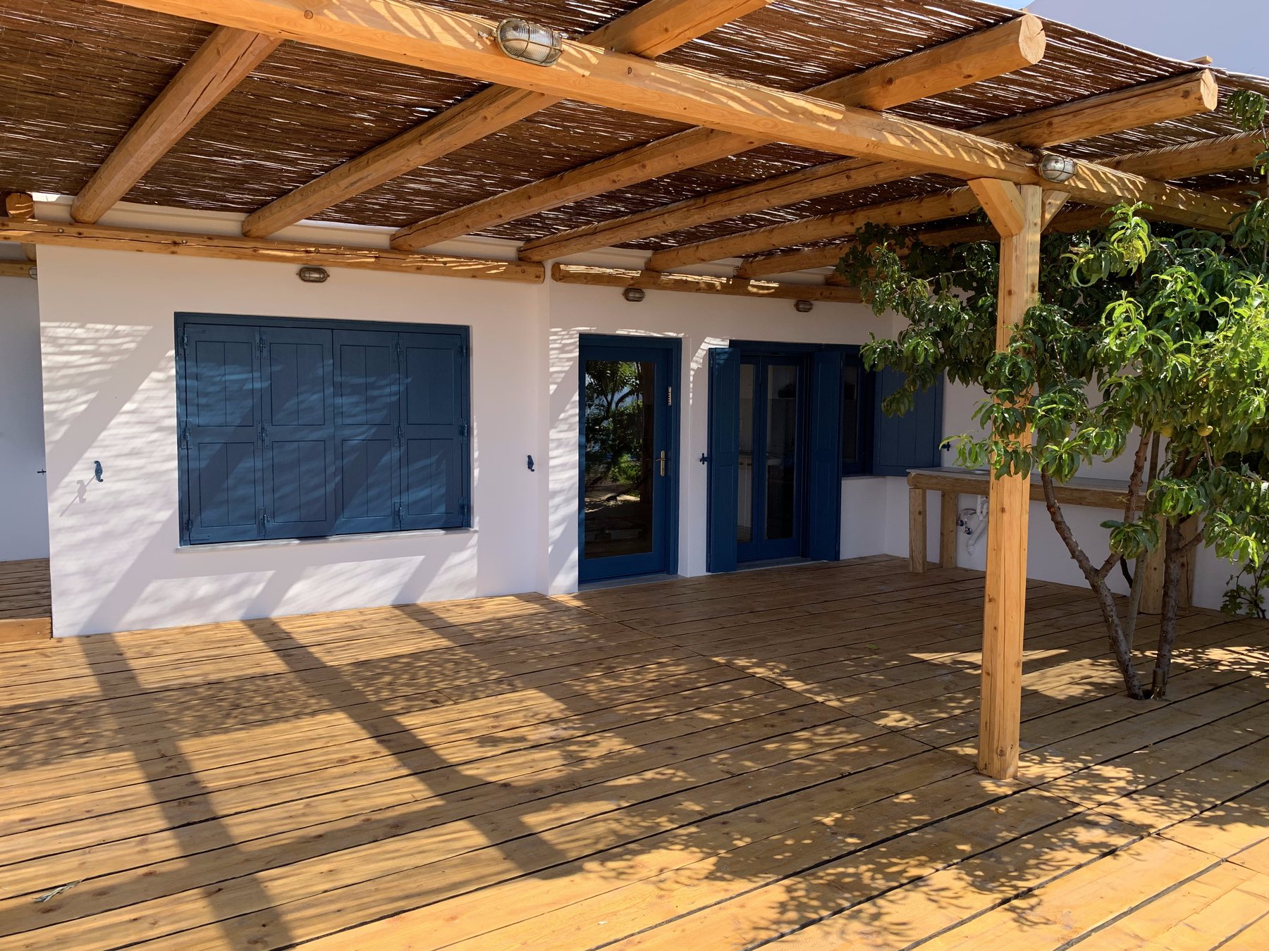 Second unit under a timber pergola with blue shutters and a wide deck