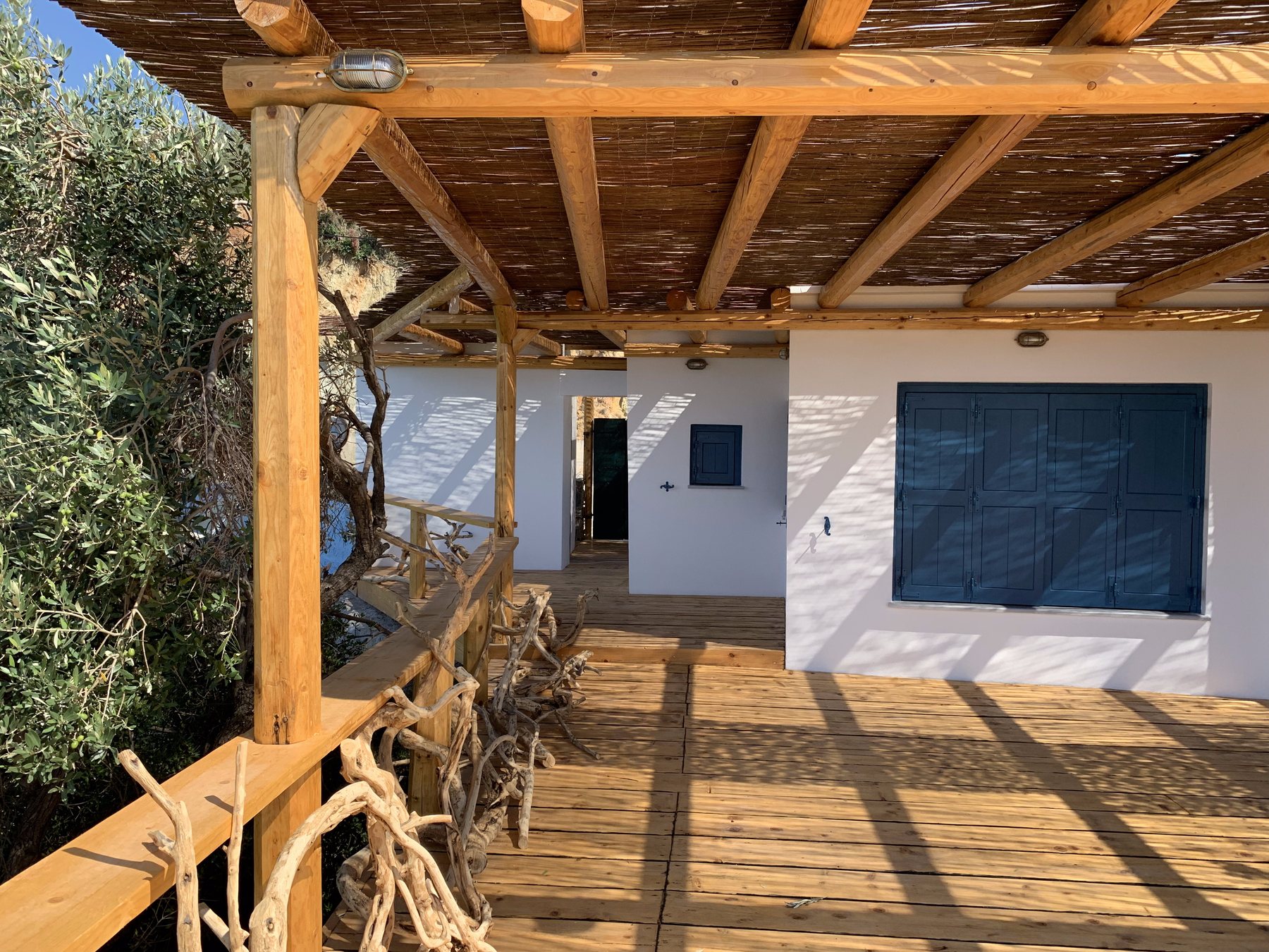 The house under its timber pergola with the wide deck