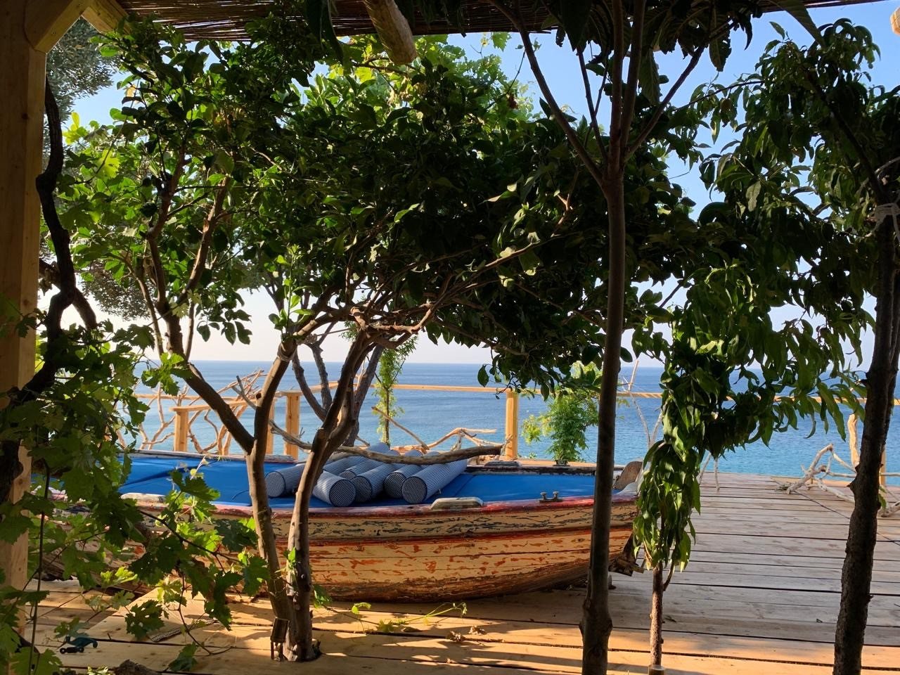 Vine-covered pergola over the deck with the sea beyond