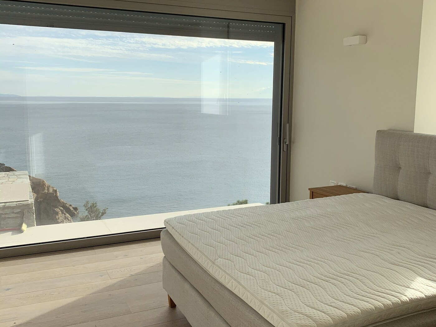Sea-view bedroom with floor-to-ceiling glass