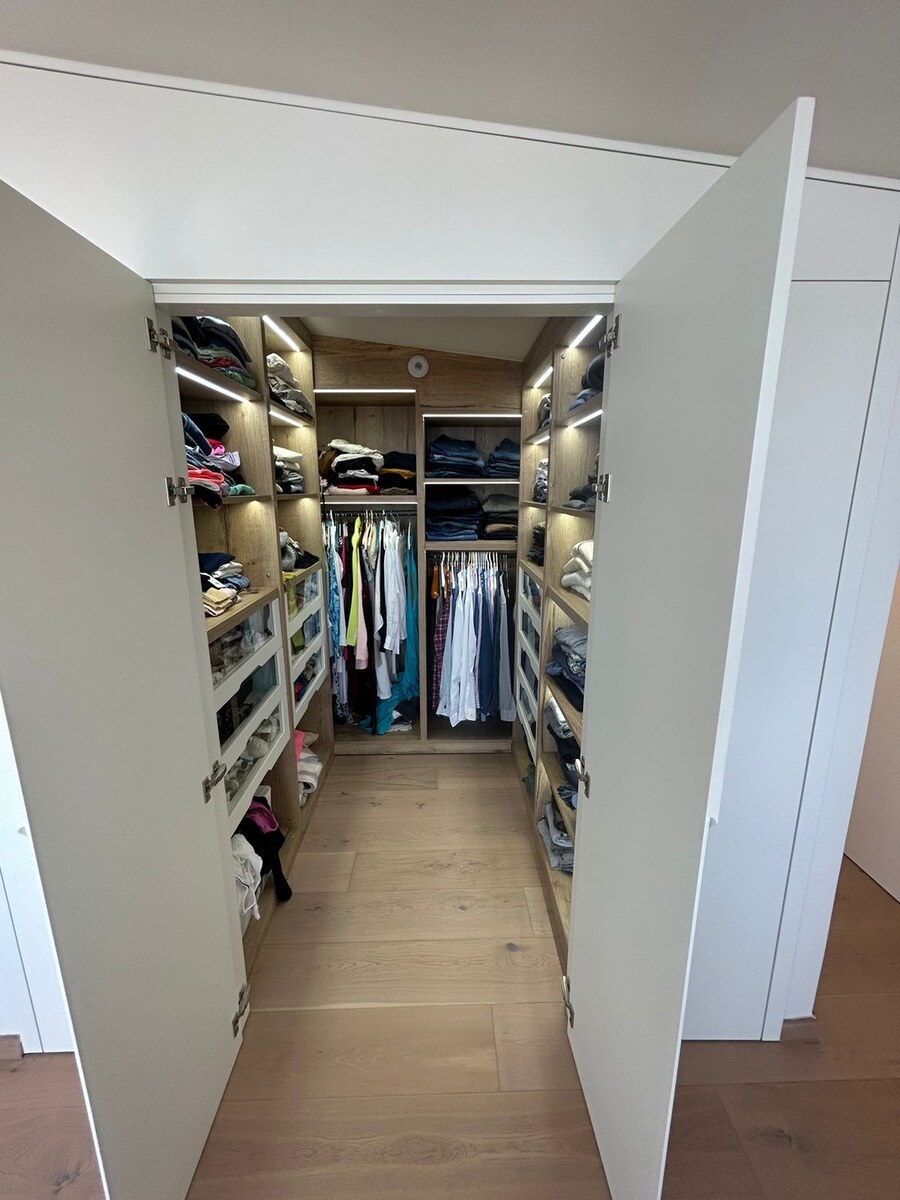 Walk-in dressing room with backlit oak cabinetry